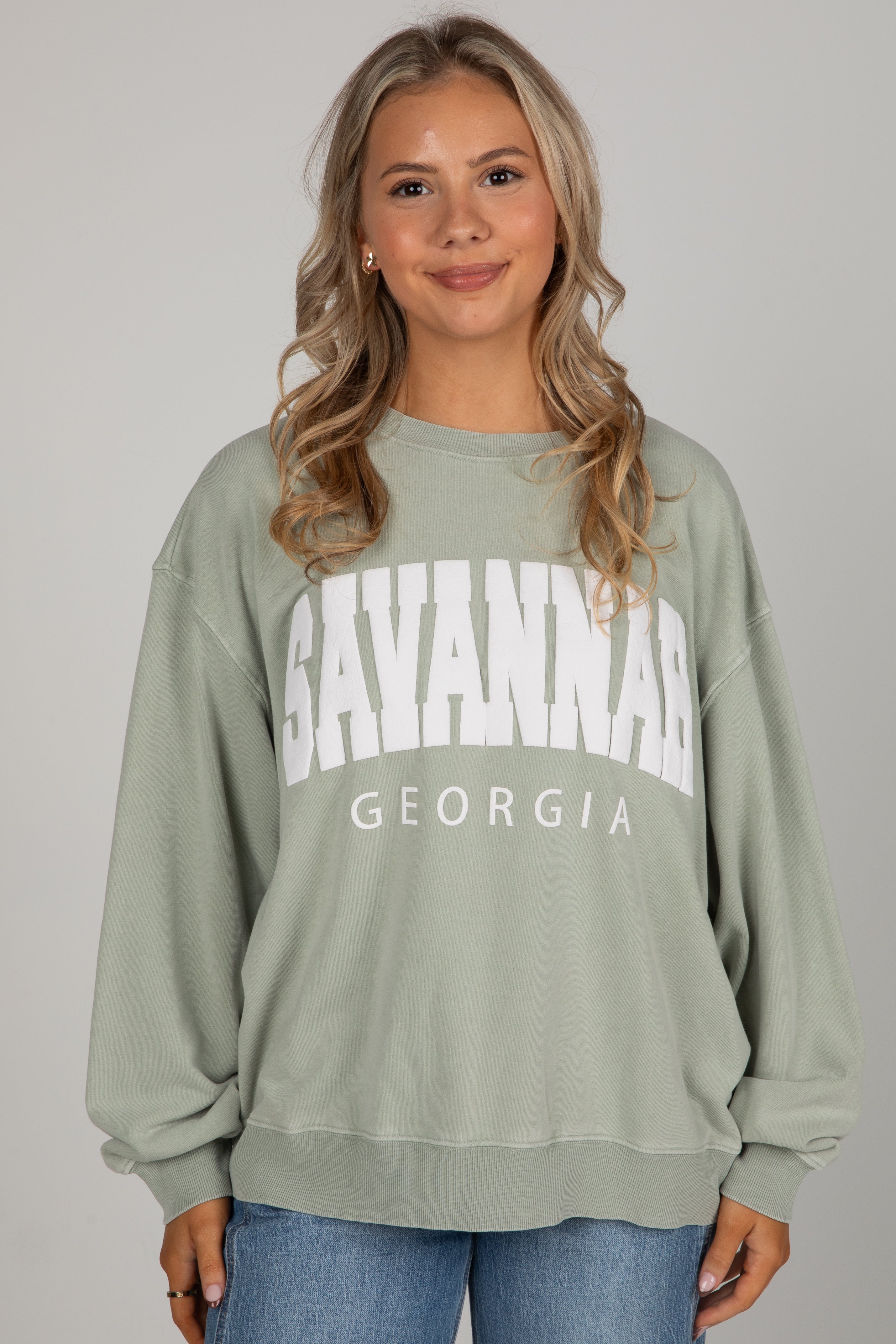 Woman wearing a green sweatshirt with &