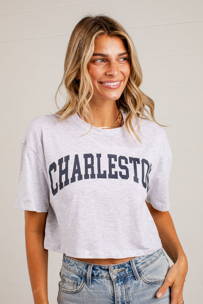A woman wearing a light heather gray cropped t-shirt with &
