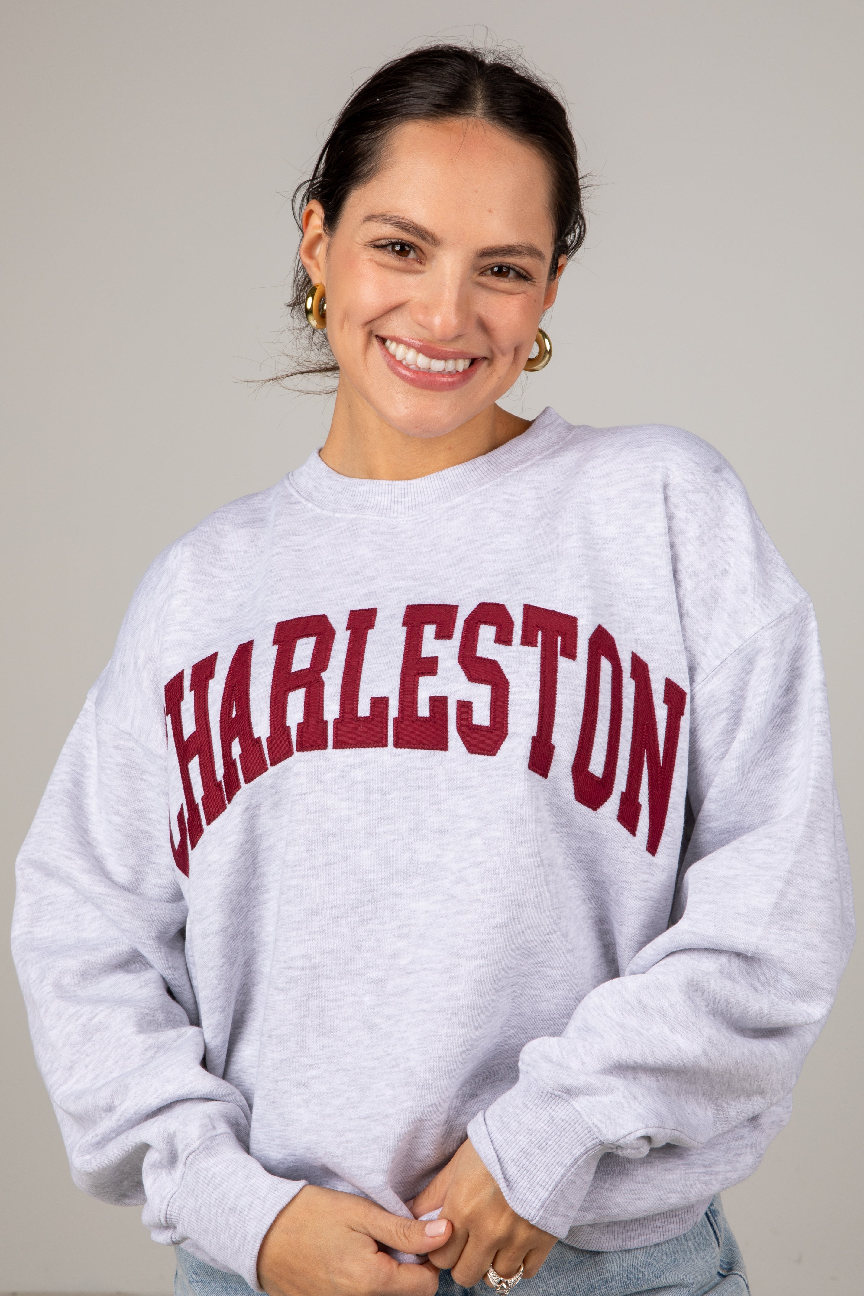 Person wearing a gray sweatshirt with &