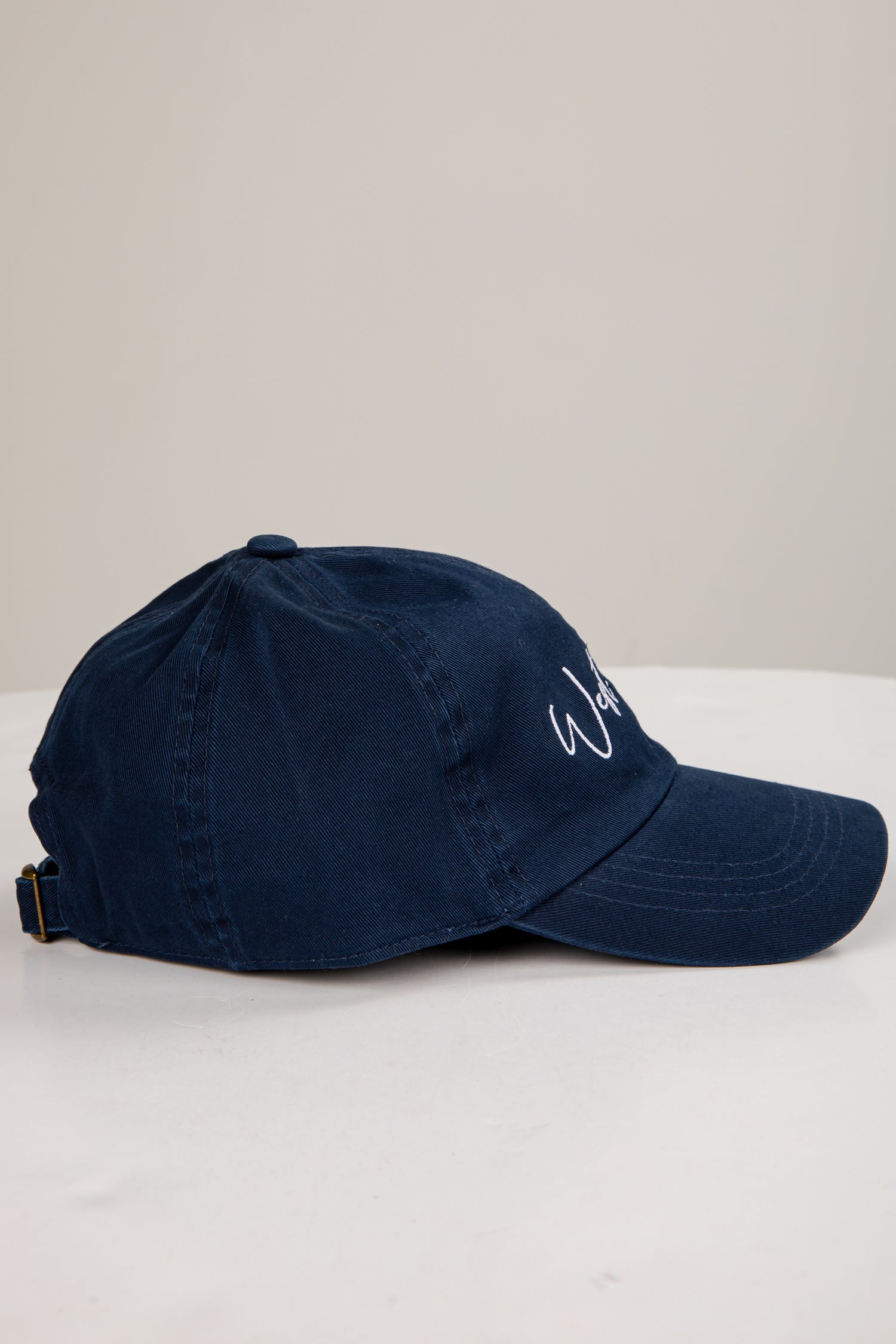 Navy blue cap with a logo on a white surface