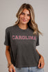 A woman wearing a dark charcoal gray short-sleeve t-shirt with &