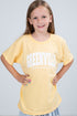 Young girl wearing a yellow t-shirt with &