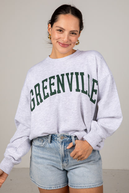 Woman wearing a gray sweatshirt with &