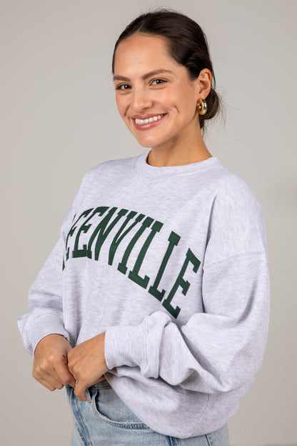 Woman wearing a gray sweatshirt with &