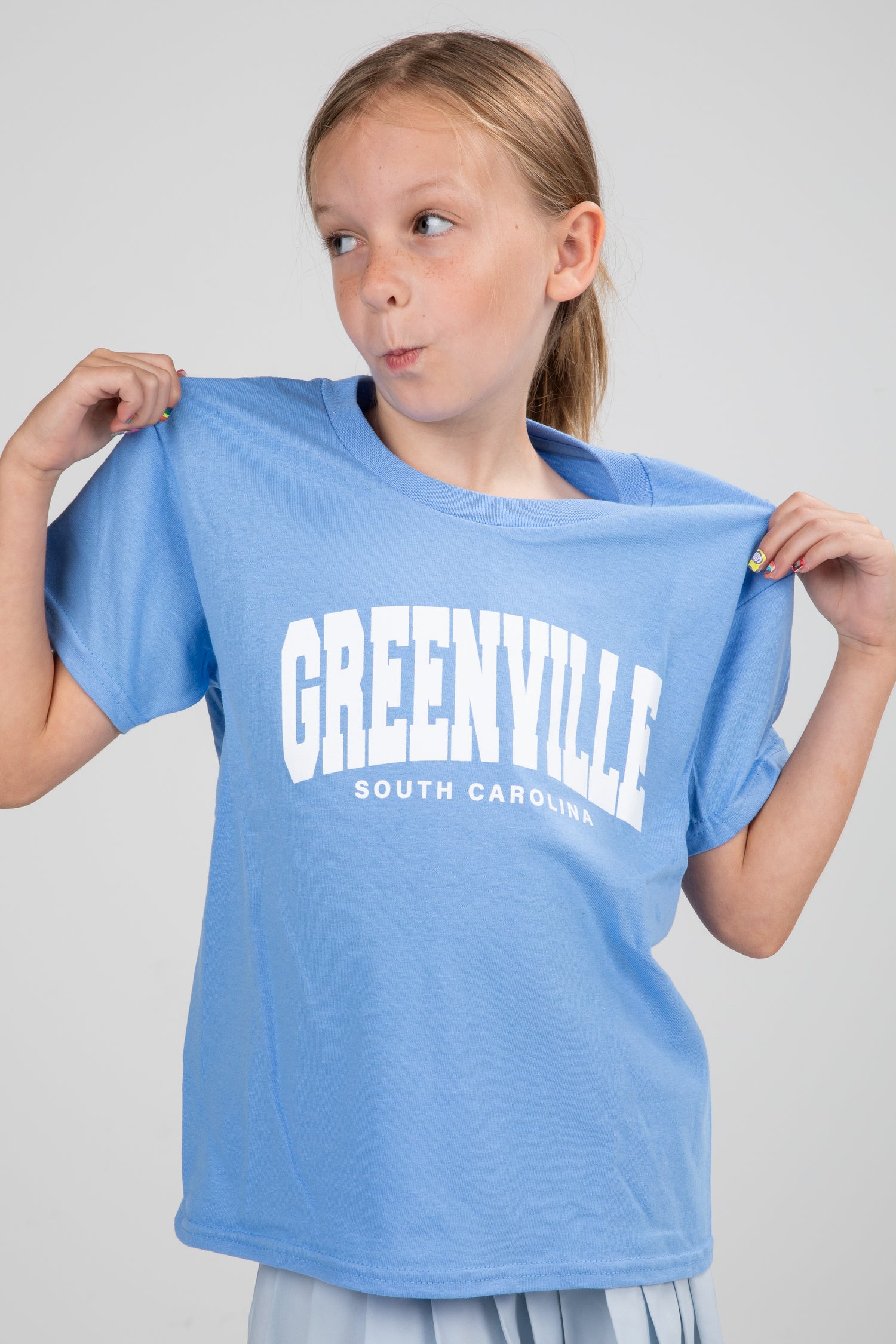 Girl holding a blue t-shirt with &