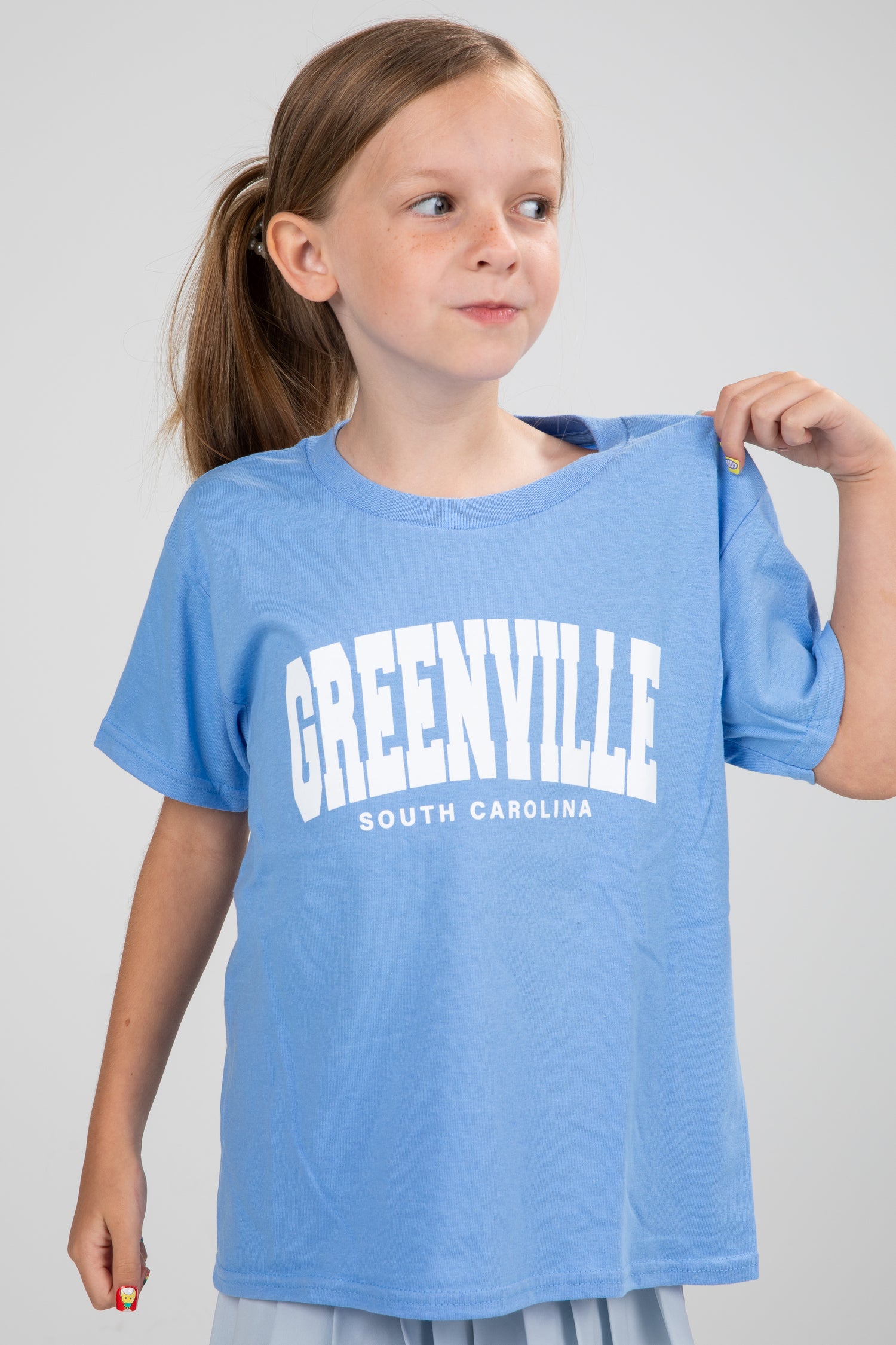 Young girl wearing a blue t-shirt with &