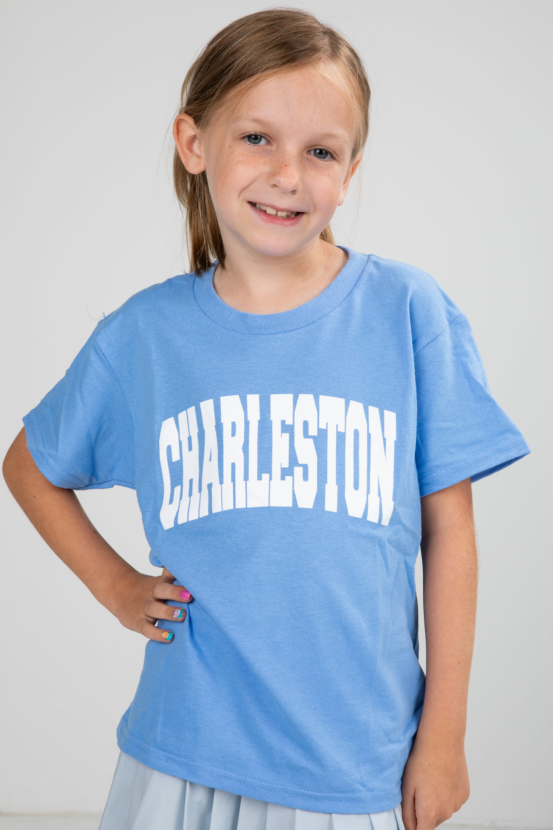 Young girl wearing a blue t-shirt with &