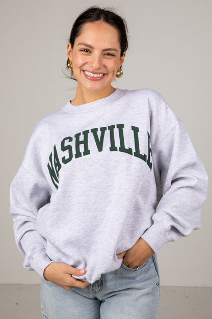 Woman wearing a gray sweatshirt with &