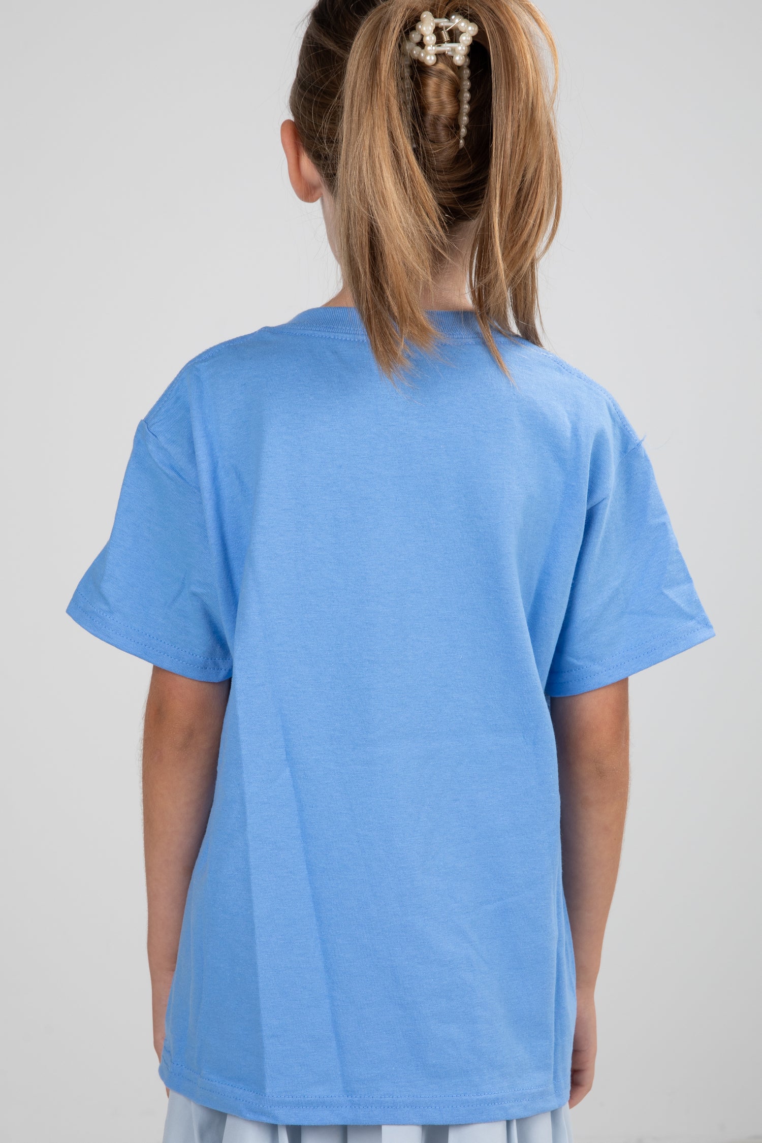 Child wearing a blue t-shirt on a plain background
