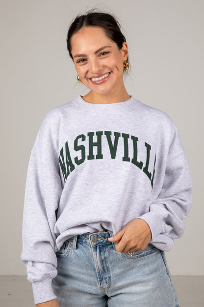 Woman wearing a gray sweatshirt with &