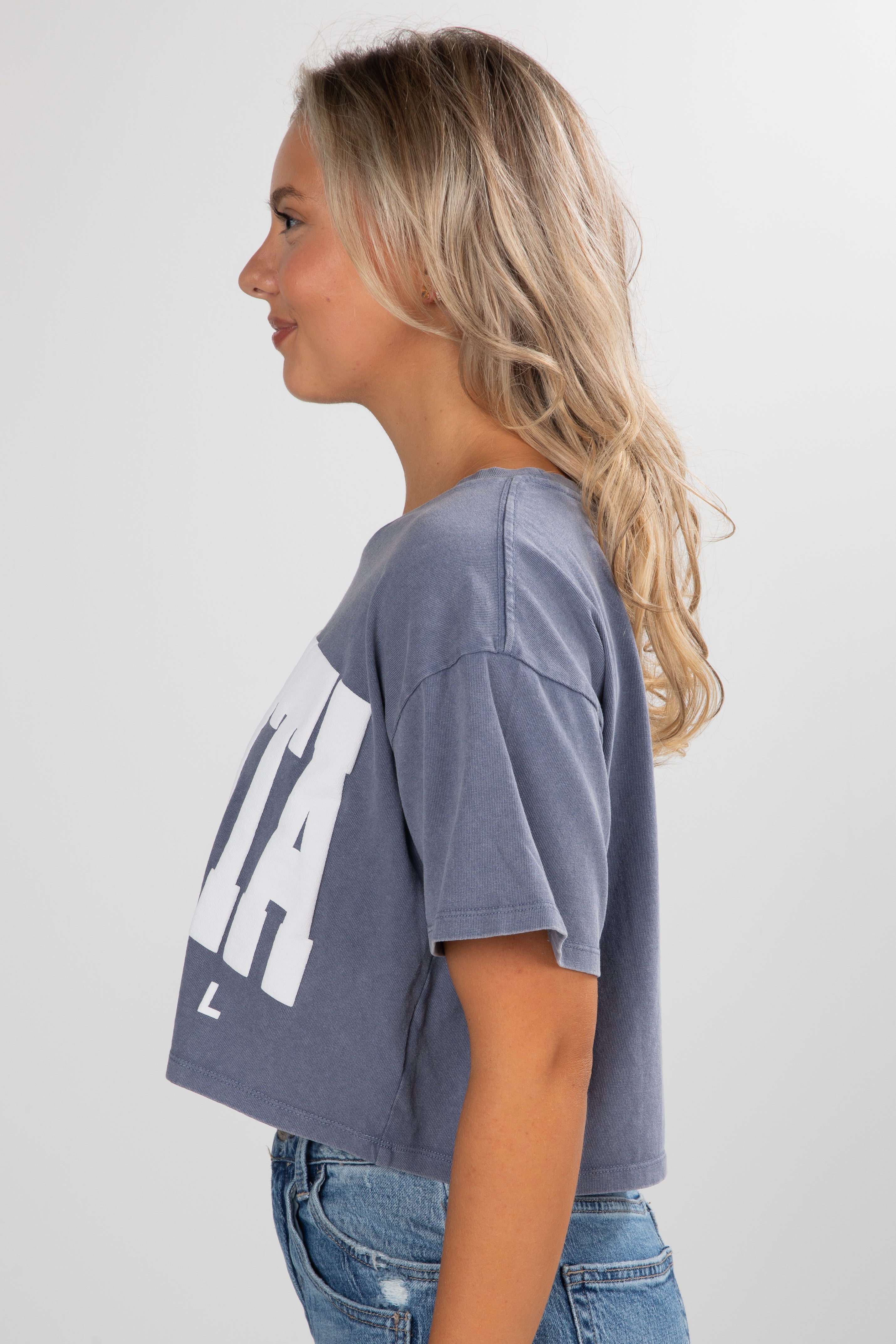 Woman wearing a gray t-shirt with a logo on a white background