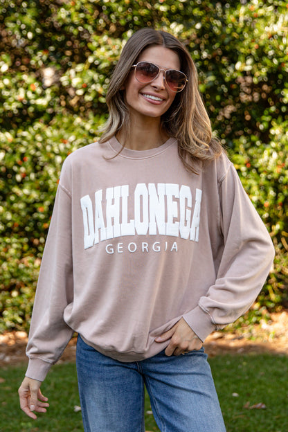 Woman wearing a beige sweatshirt with &