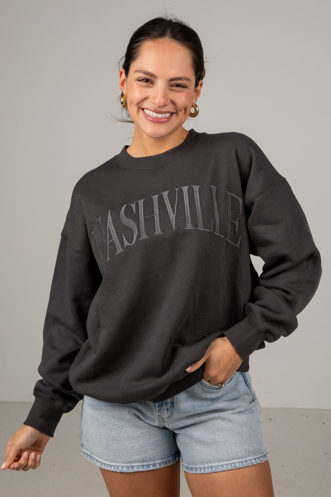 Woman wearing a black sweatshirt with &