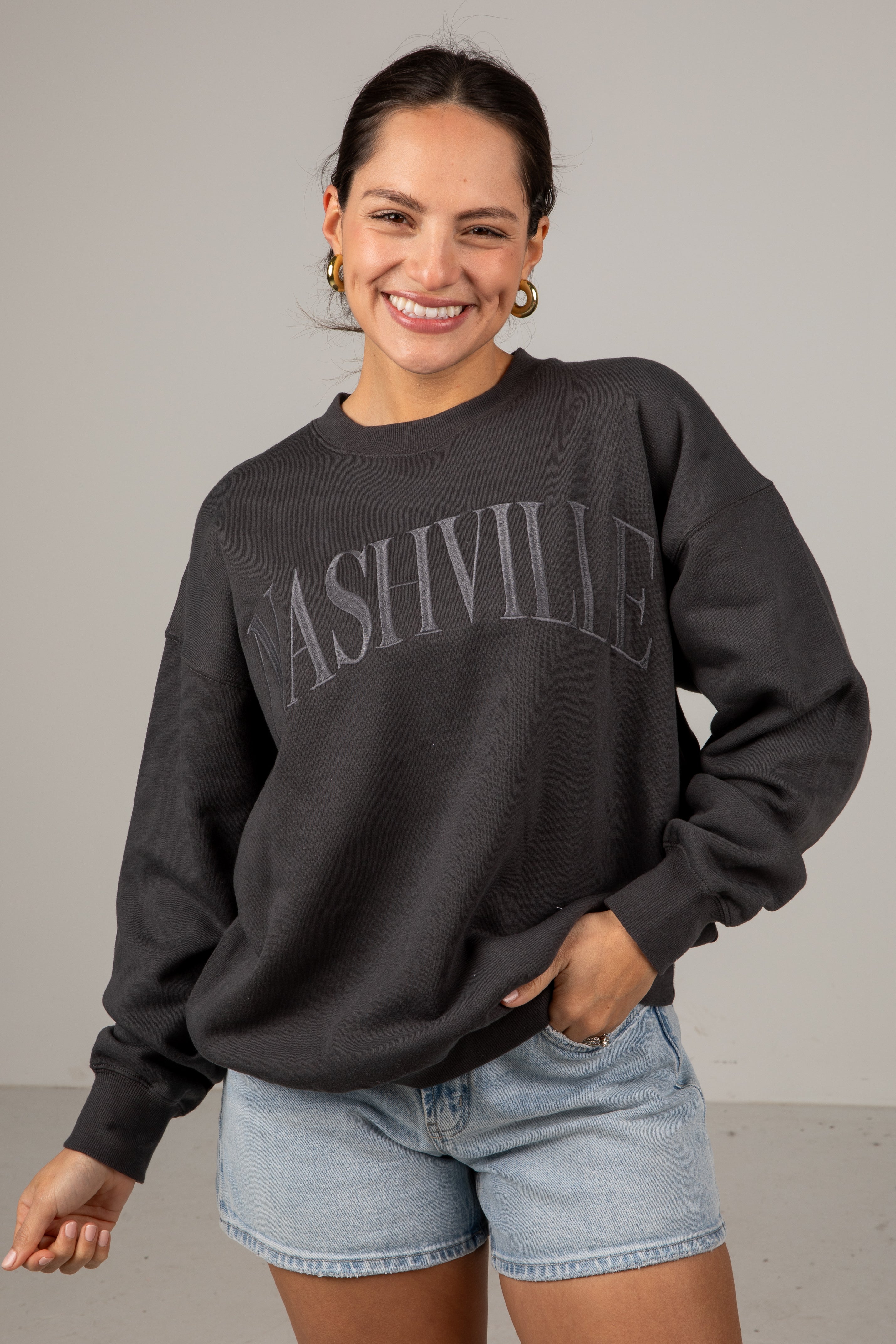 Woman wearing a black sweatshirt with &