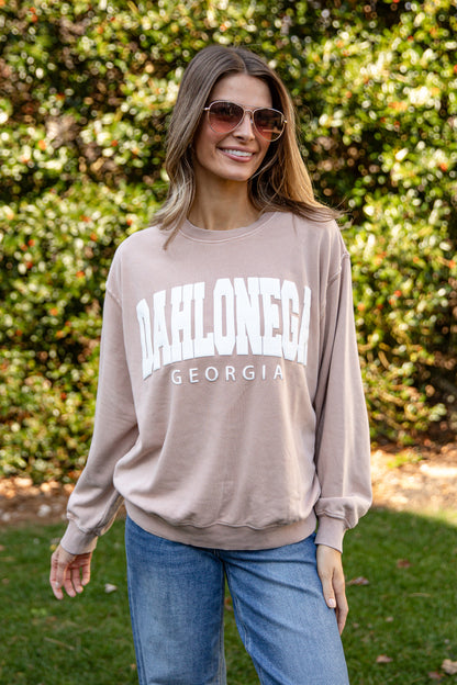 Woman wearing a beige sweatshirt with &
