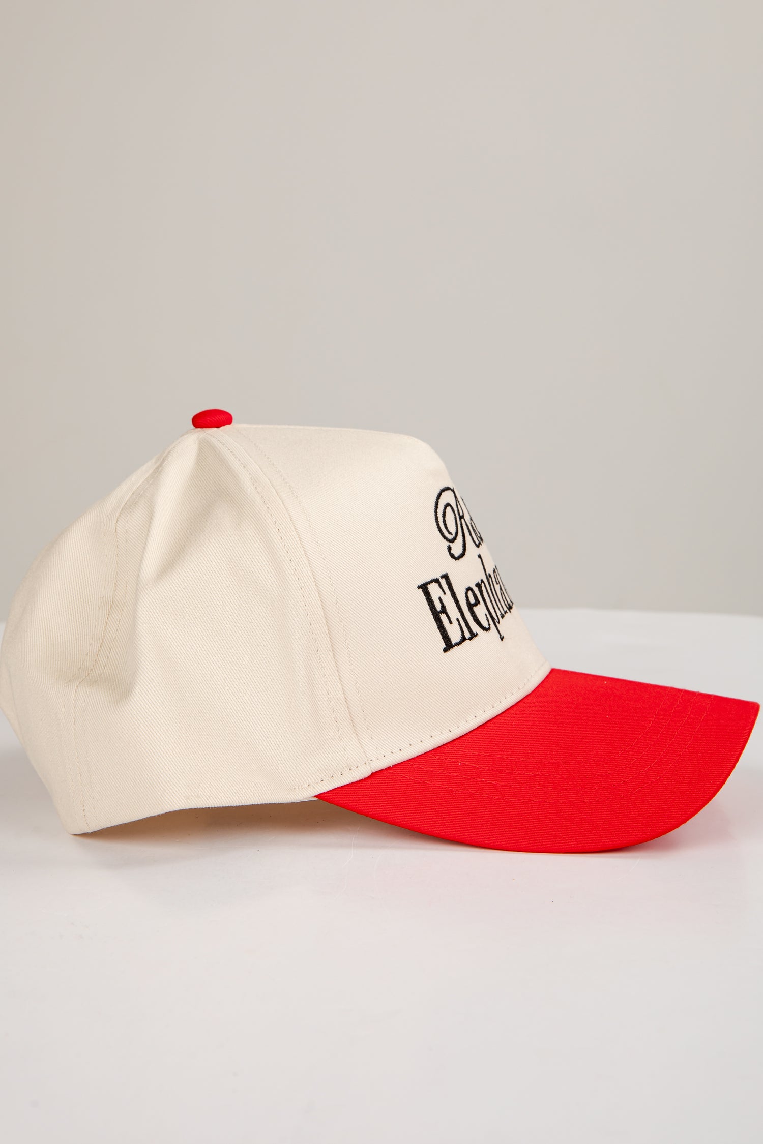 Baseball cap with white front and red back on a light gray background