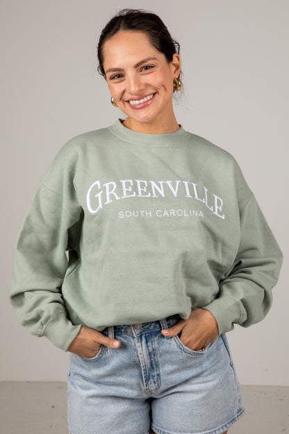 Woman wearing a green sweatshirt with &