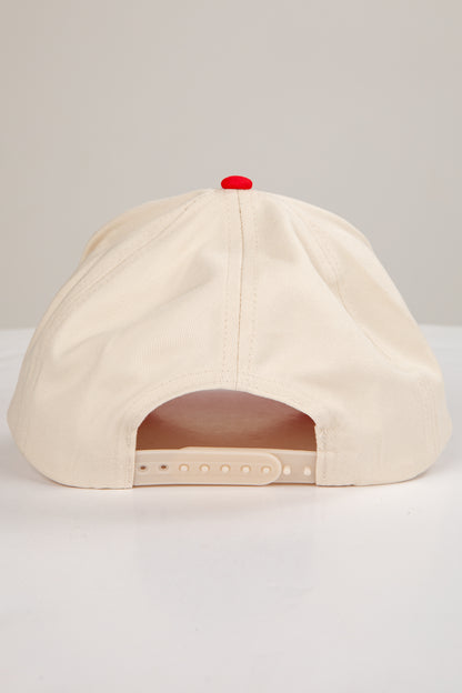 Beige cap with a red button on a light gray background