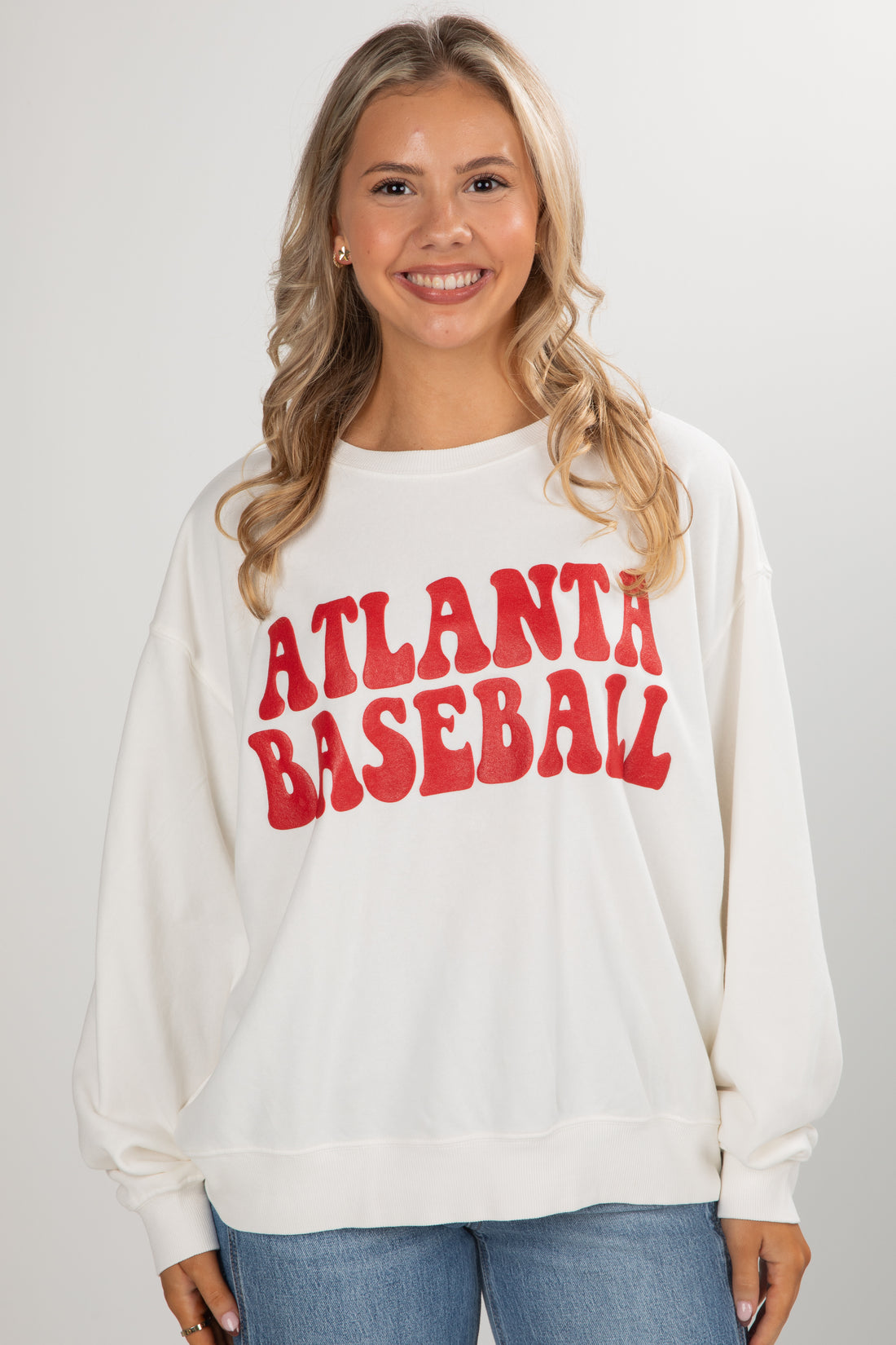 Woman wearing a white sweatshirt with &