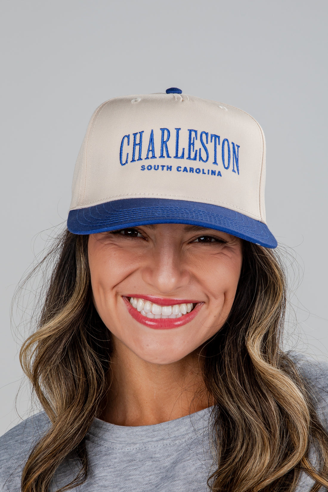 Woman wearing a beige and blue cap with &