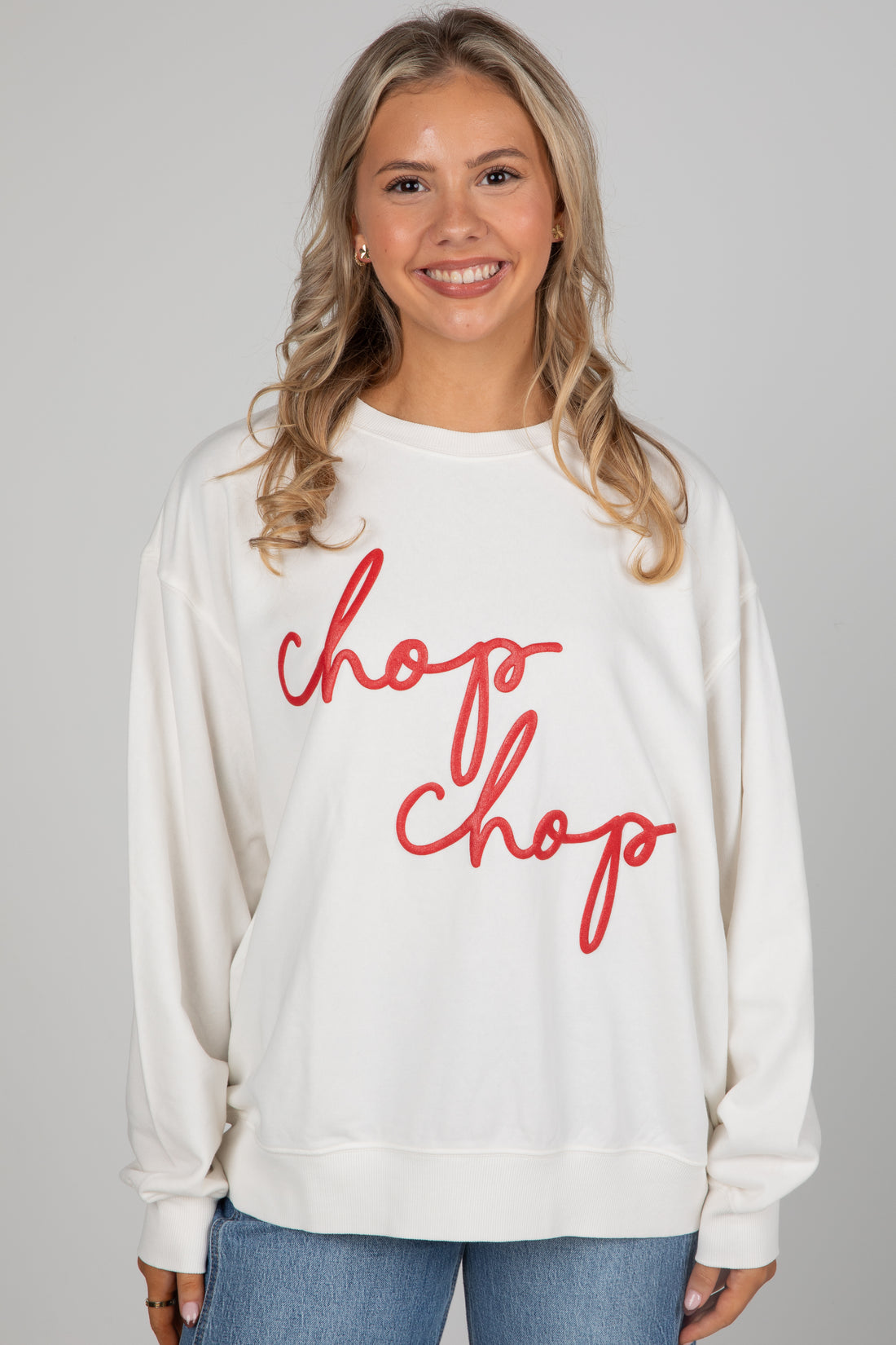 Woman wearing a white sweatshirt with &