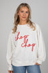 Woman wearing a white sweatshirt with red text &