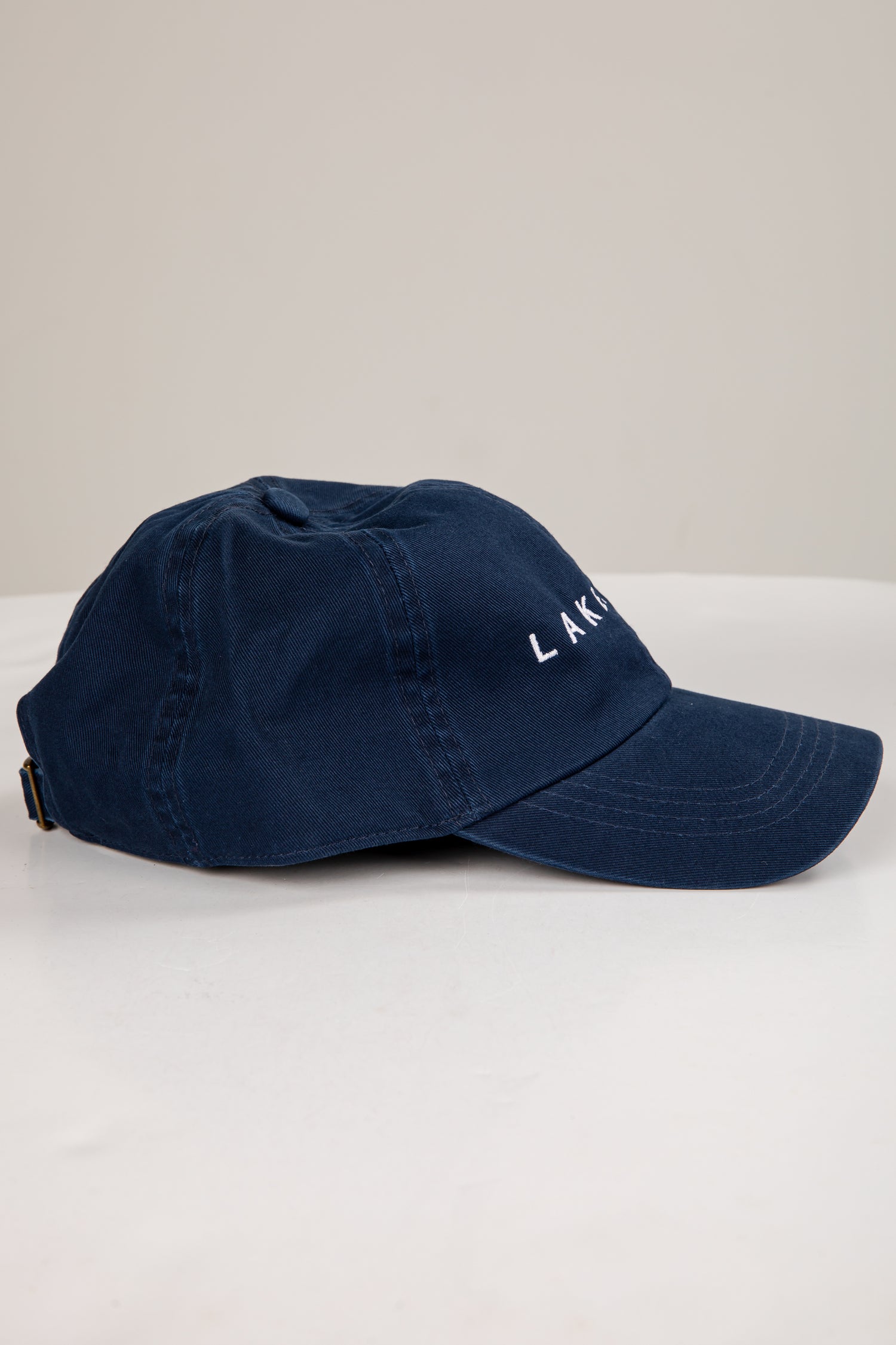 Navy blue cap with white text on a light gray background