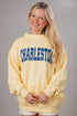 Woman wearing a yellow sweatshirt with &