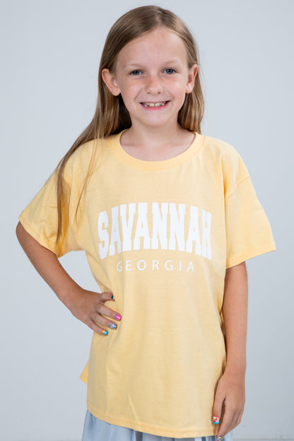 Young girl wearing a yellow t-shirt with &