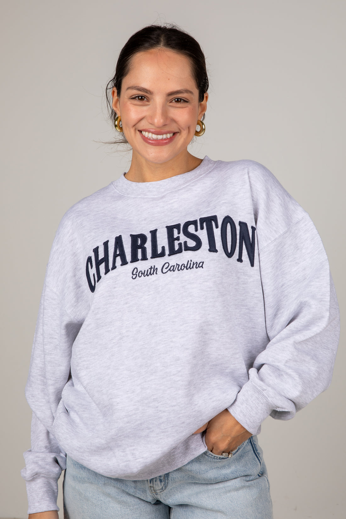 Woman wearing a gray sweatshirt with &