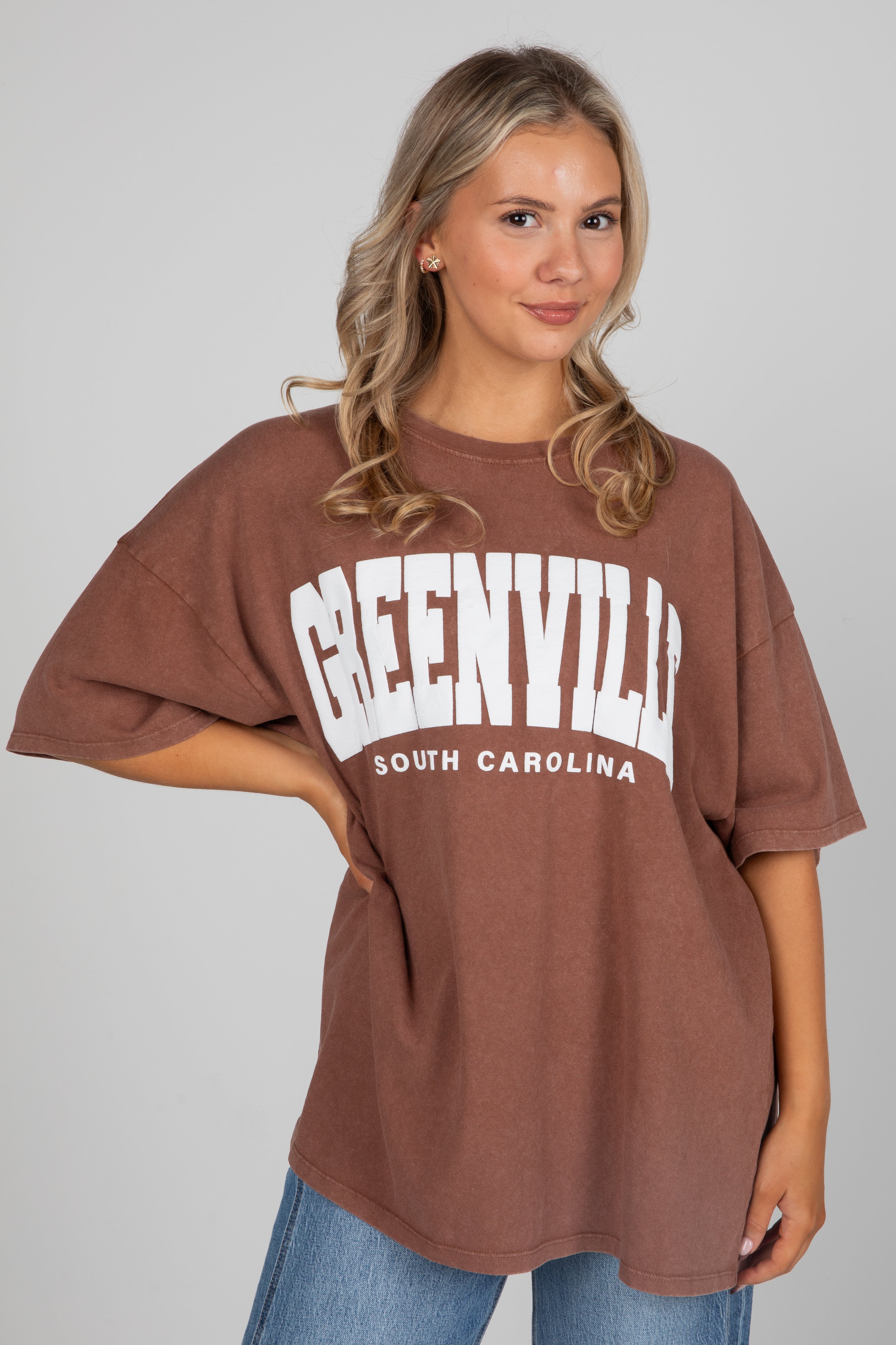 Woman wearing a brown oversized t-shirt with &