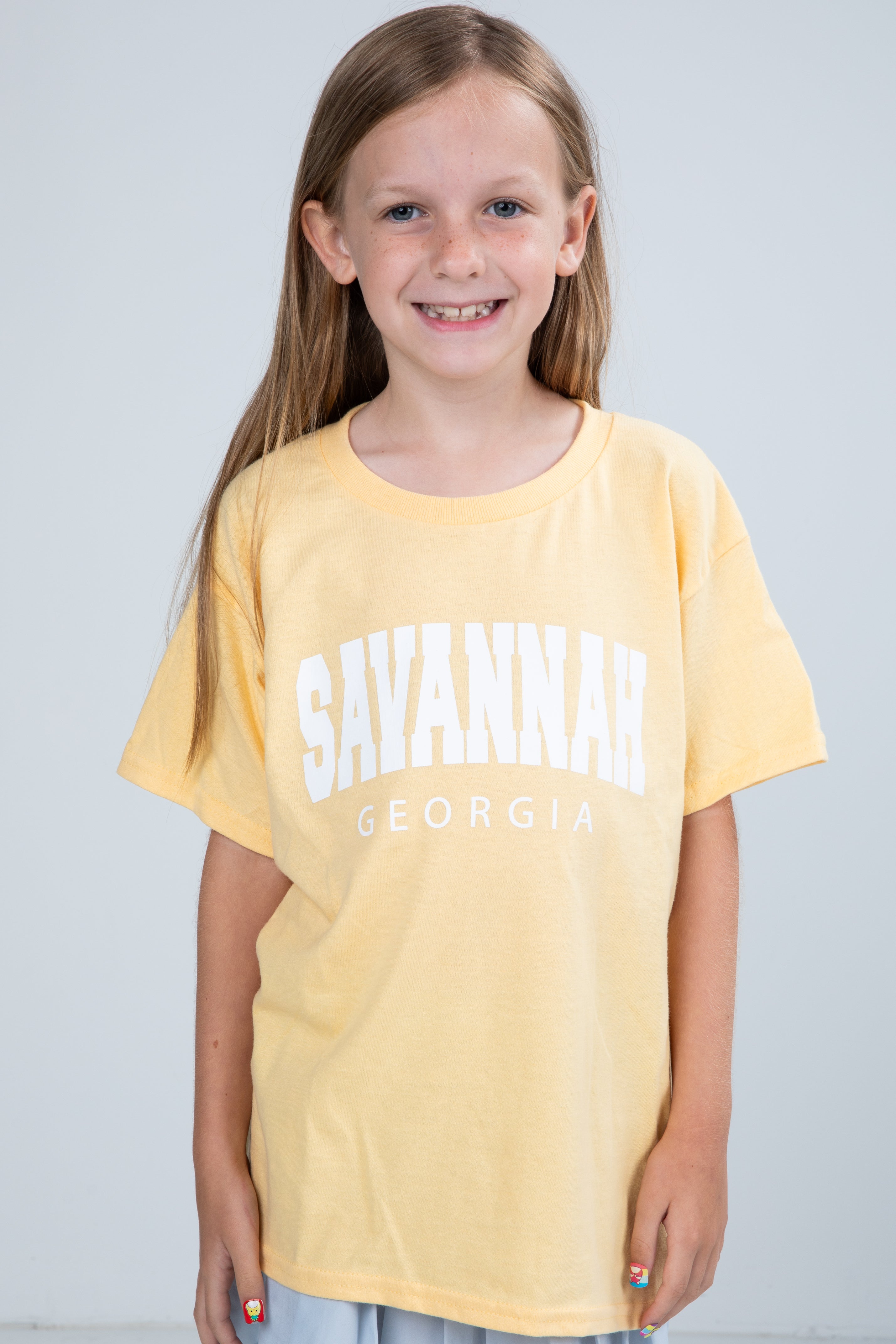 Young girl wearing a yellow t-shirt with &