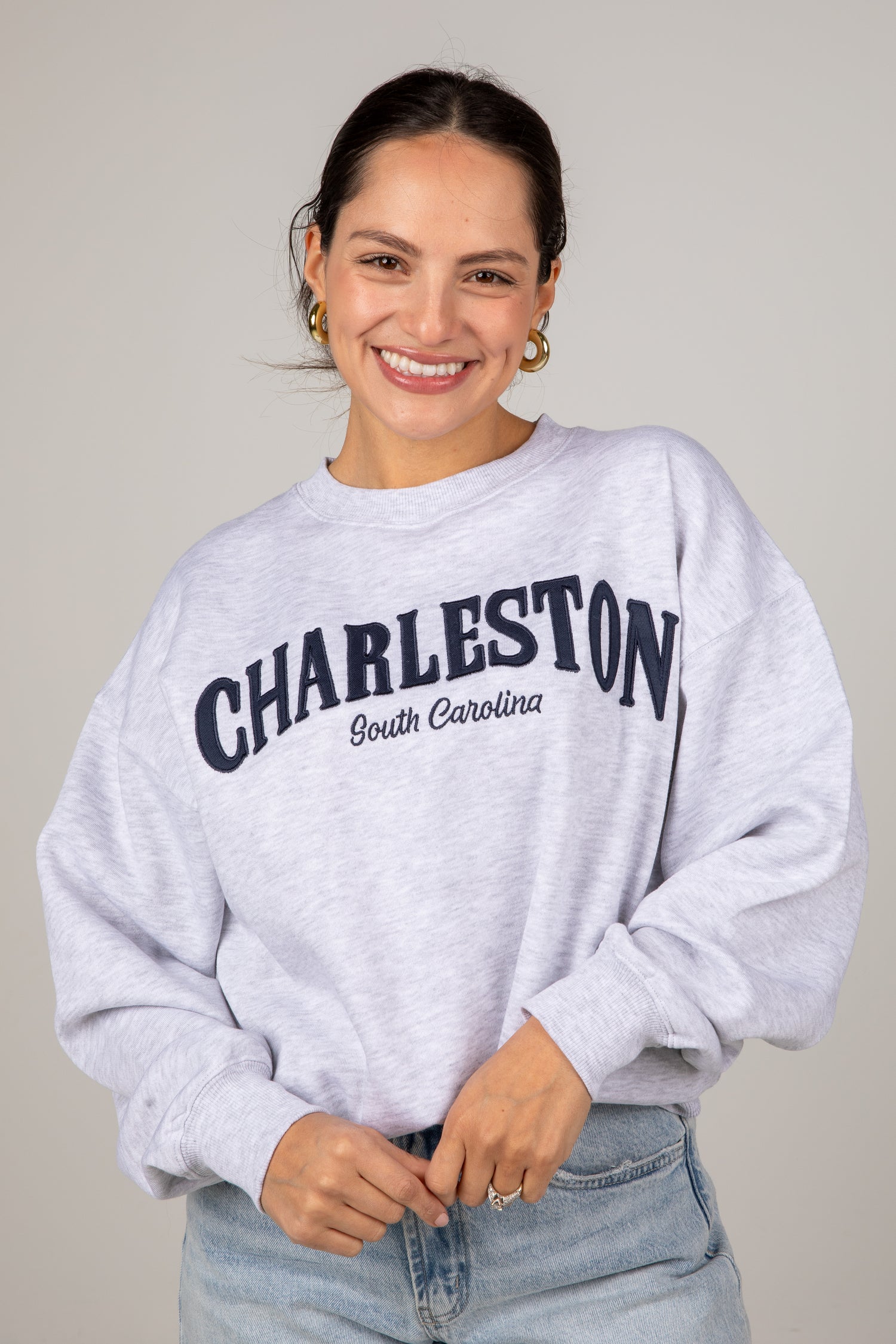 Woman wearing a gray sweatshirt with &