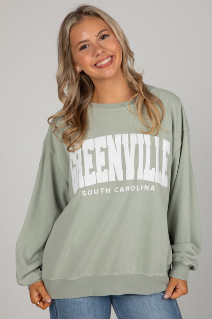 Woman wearing a green sweatshirt with &