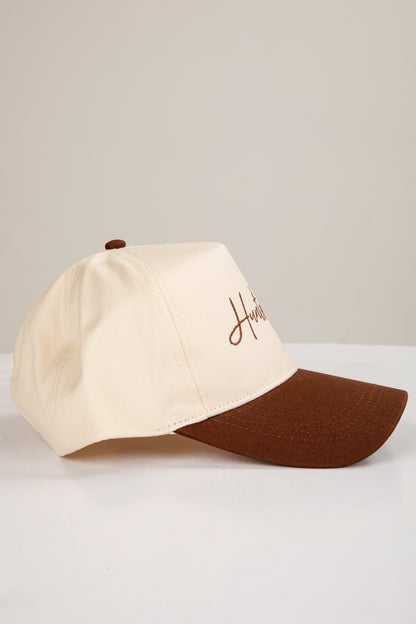 Two-tone beige and brown cap on a light gray background