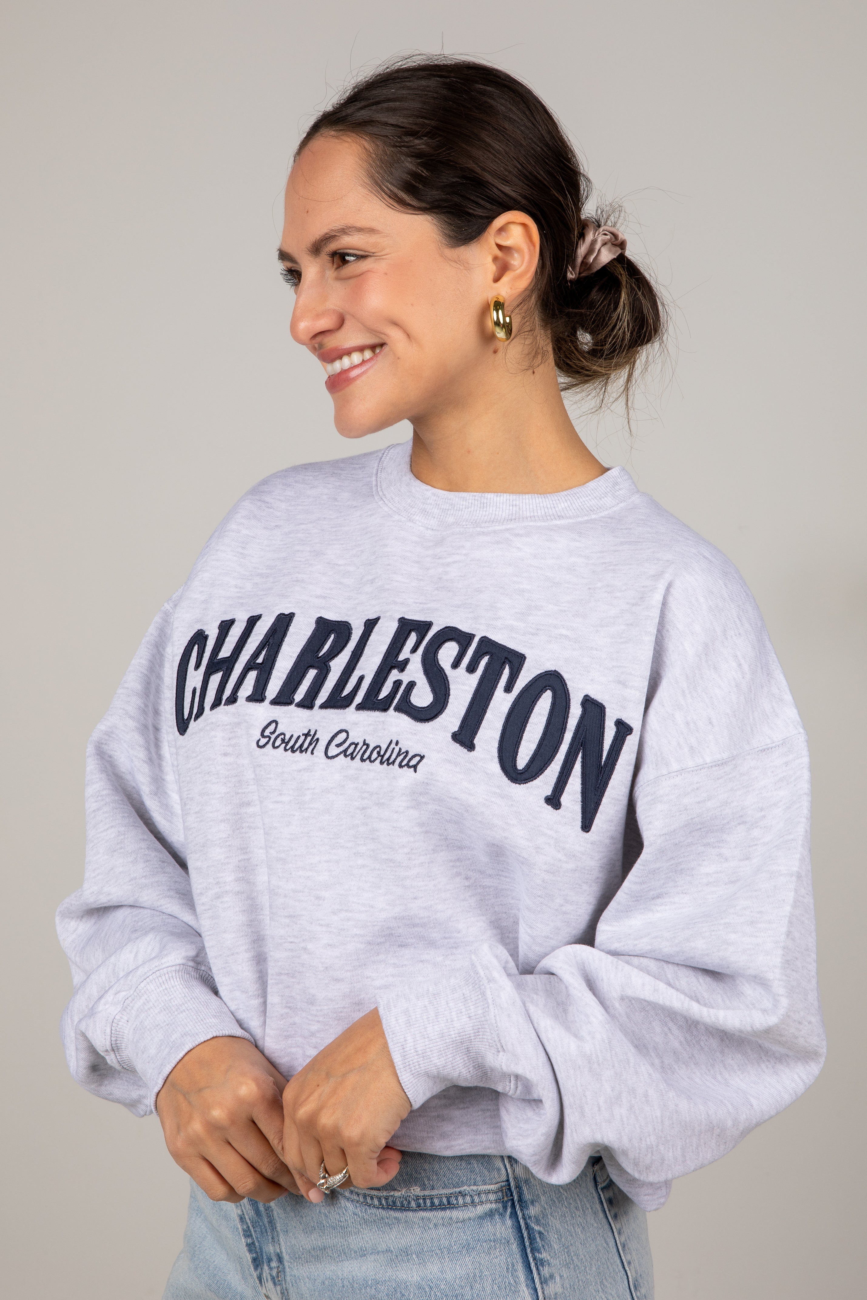 Woman wearing a gray sweatshirt with &