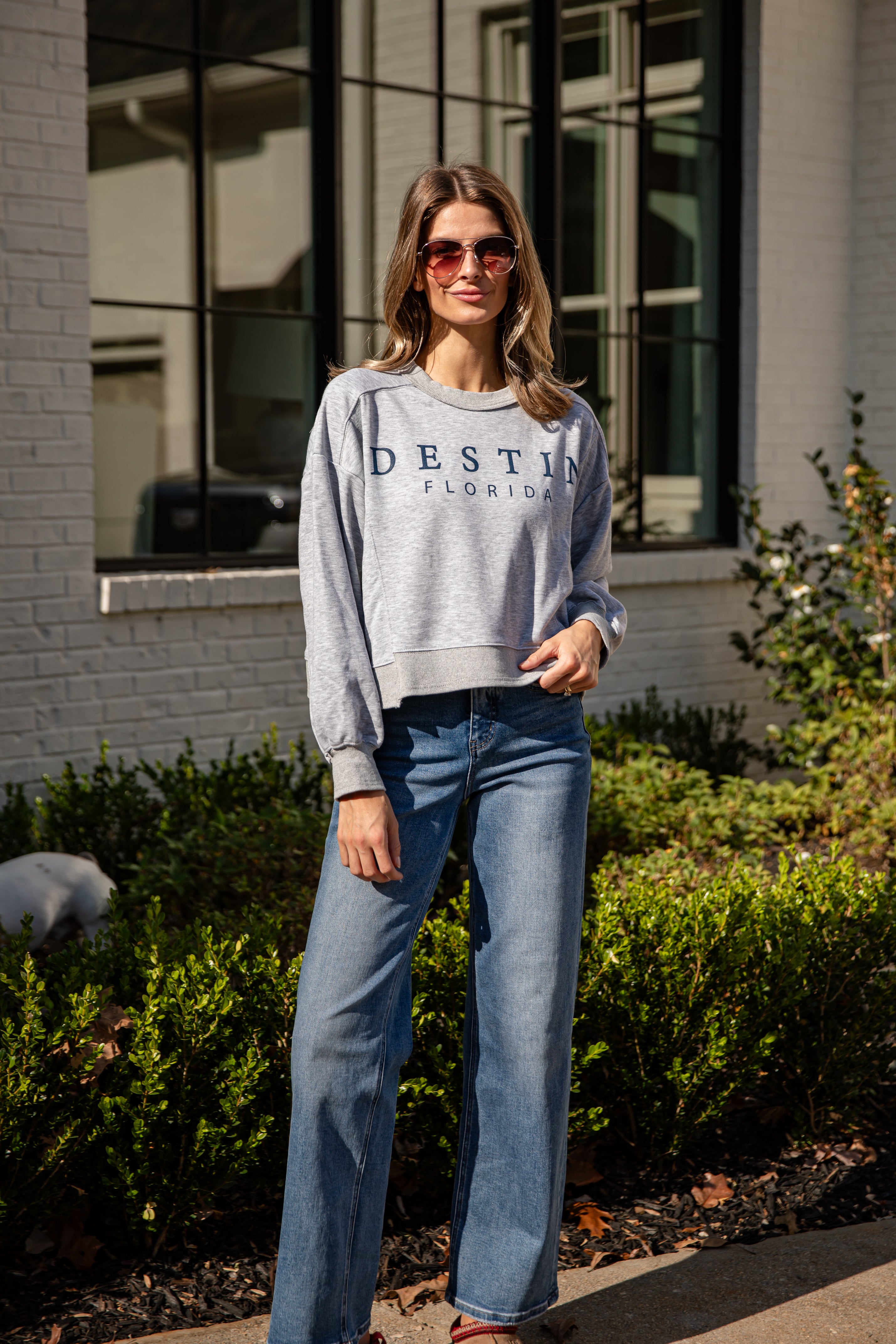 Woman wearing a gray sweatshirt with &