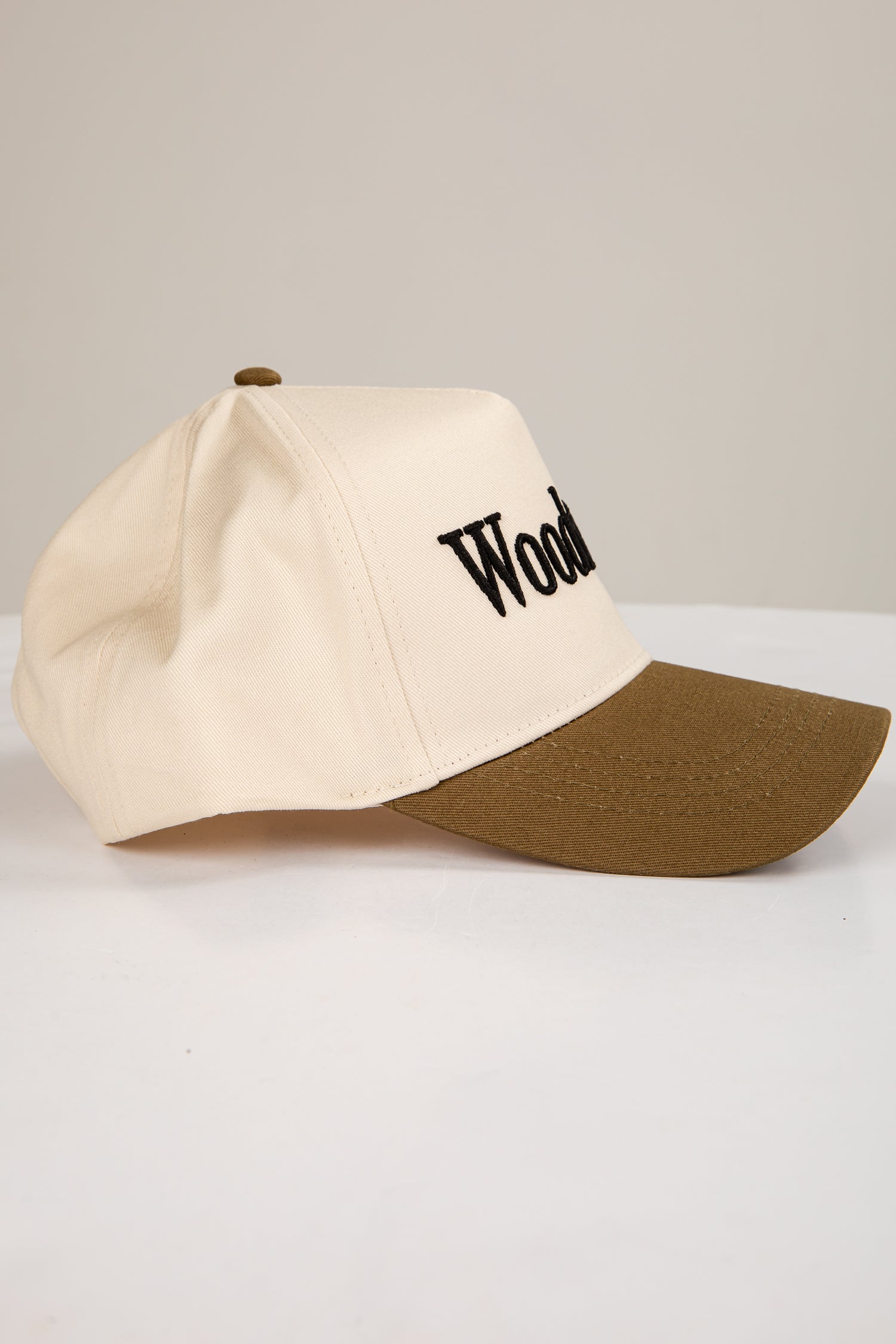 Two-tone cap with beige front and brown back on a light gray background