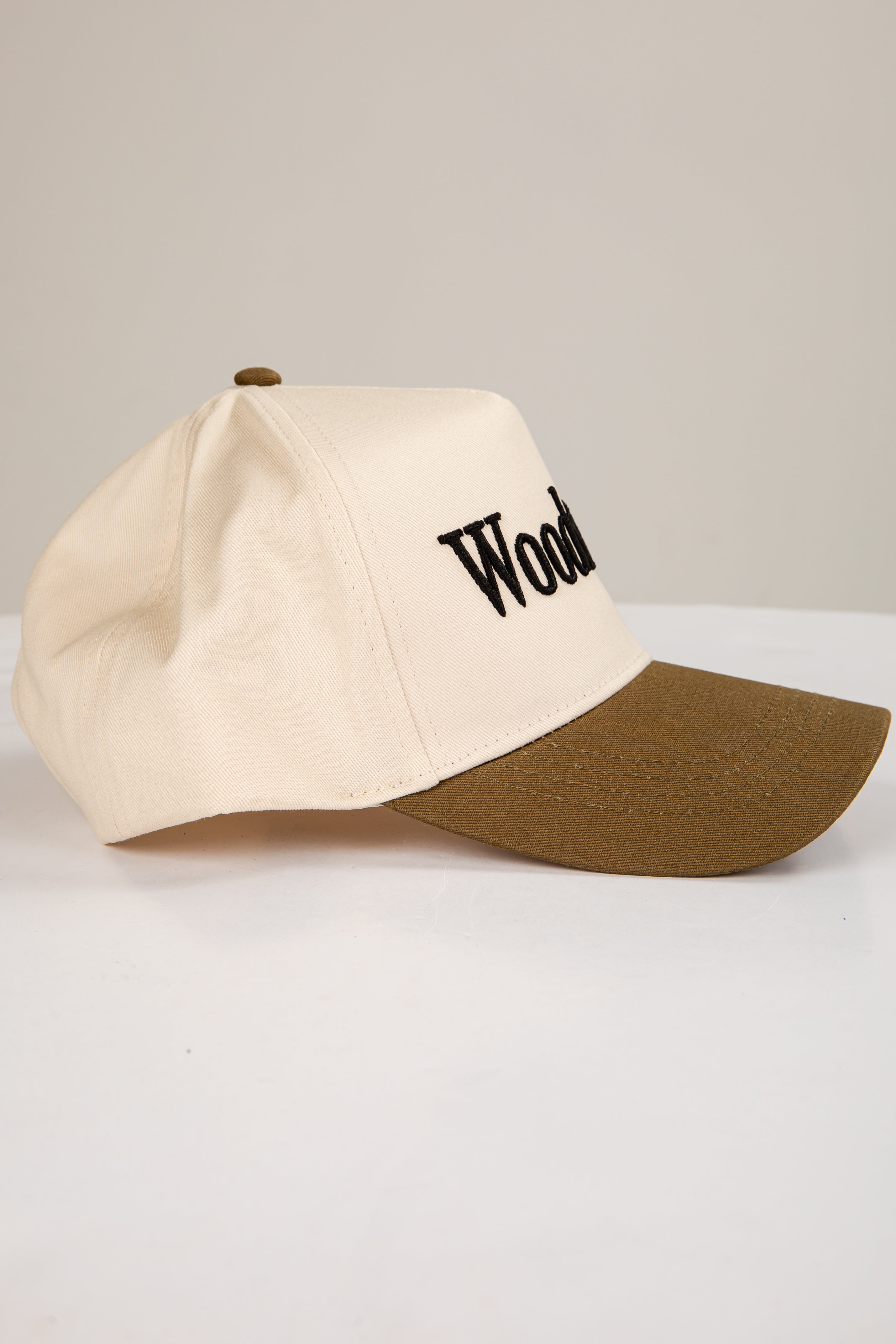Two-tone cap with beige front and brown back on a light gray background