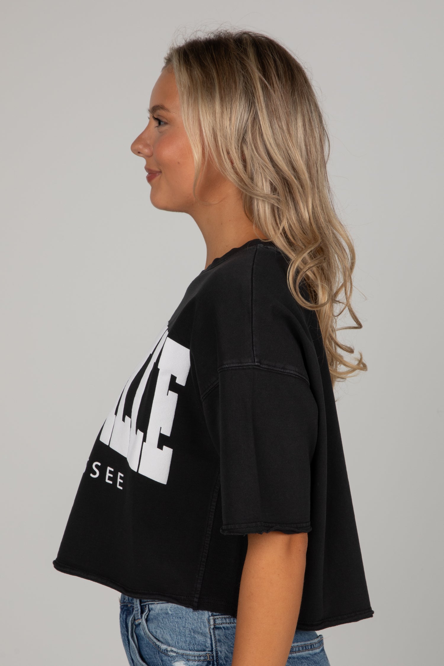 Woman wearing a black t-shirt with white text on a gray background