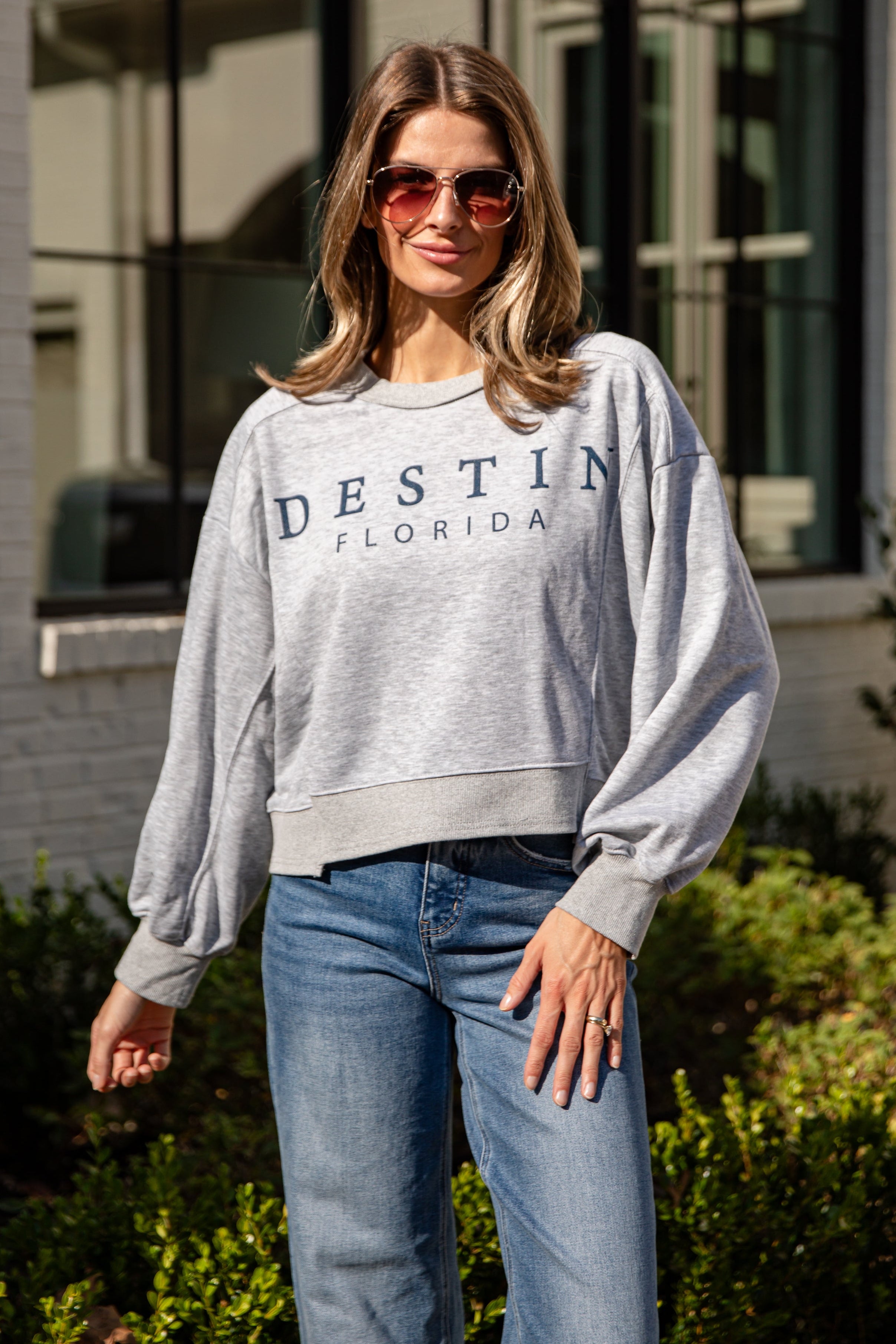 Woman wearing a gray sweatshirt with &