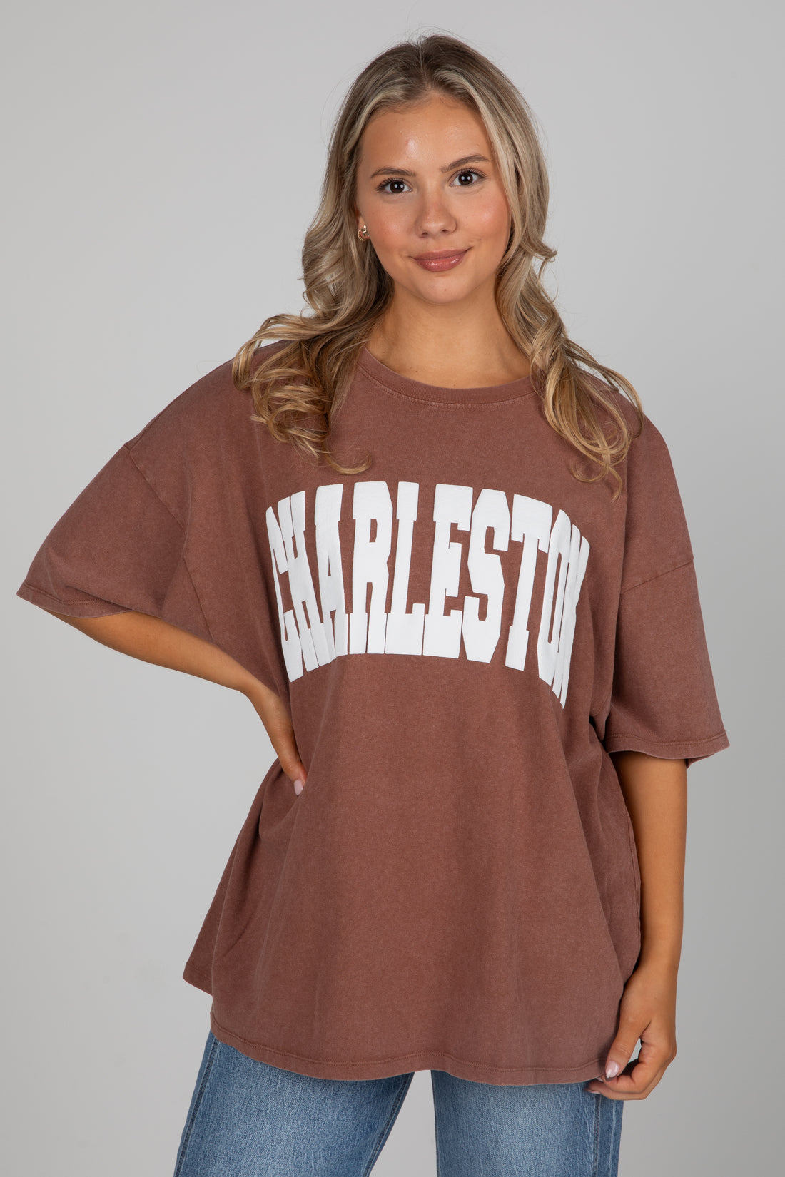 Woman wearing a brown oversized t-shirt with &