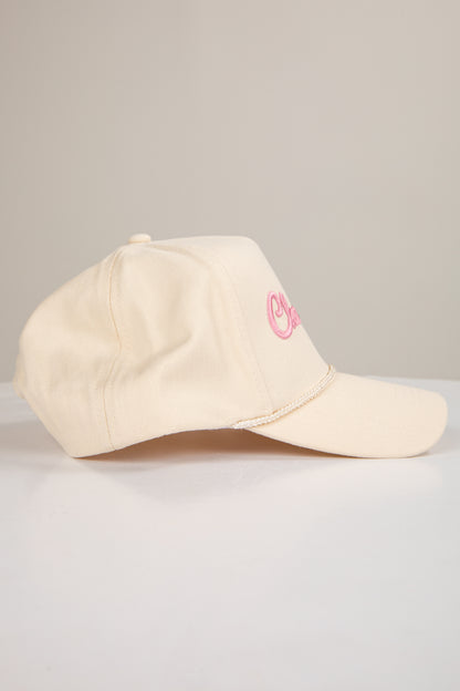 Beige cap with pink logo on a light gray background