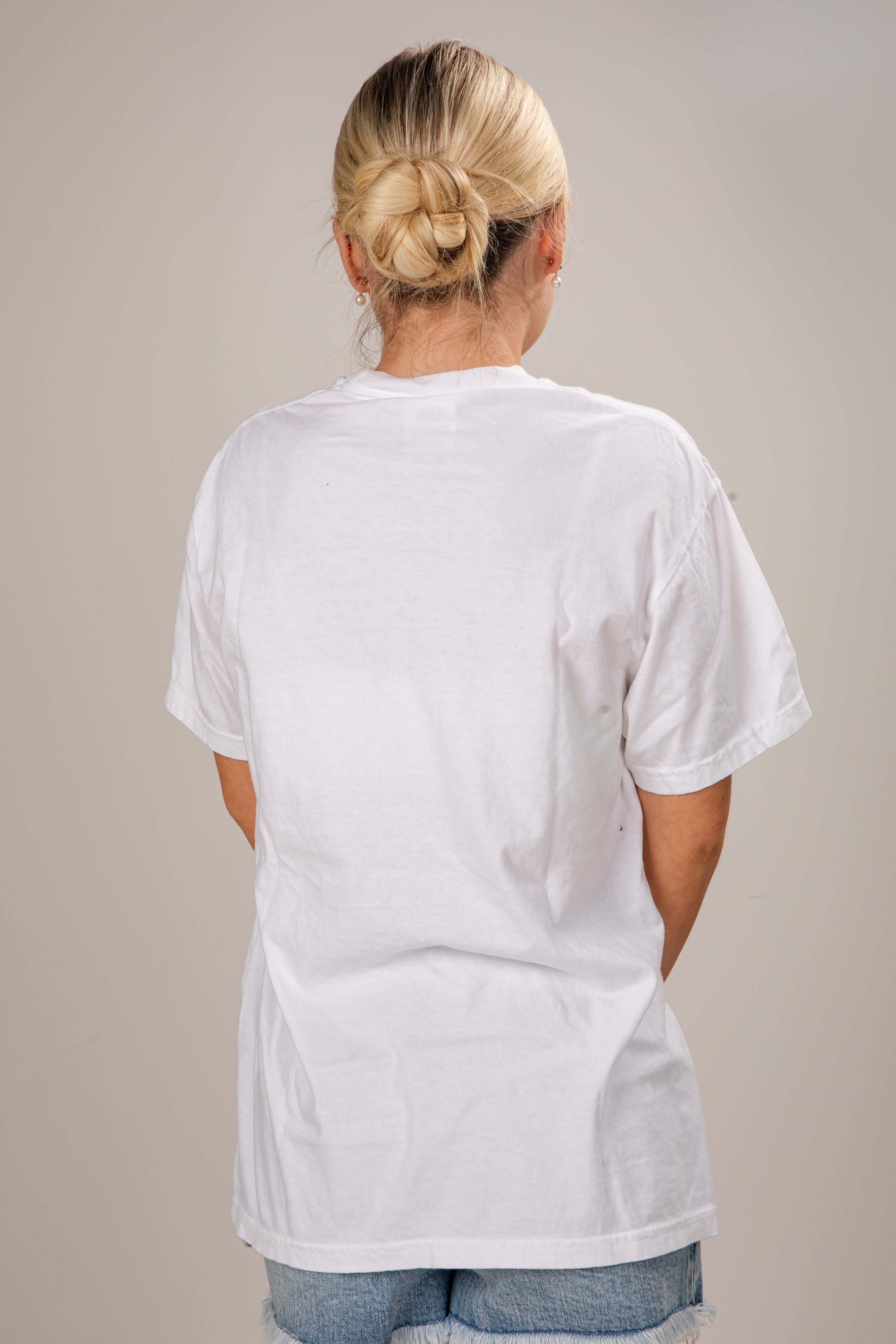 Person wearing a plain white t-shirt against a neutral background