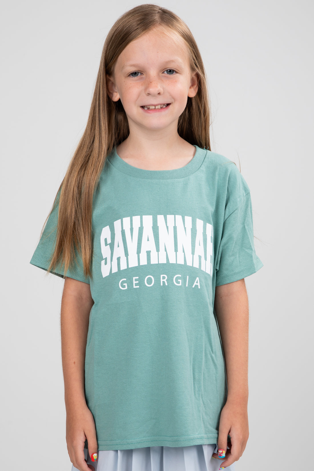 Young girl wearing a teal t-shirt with &