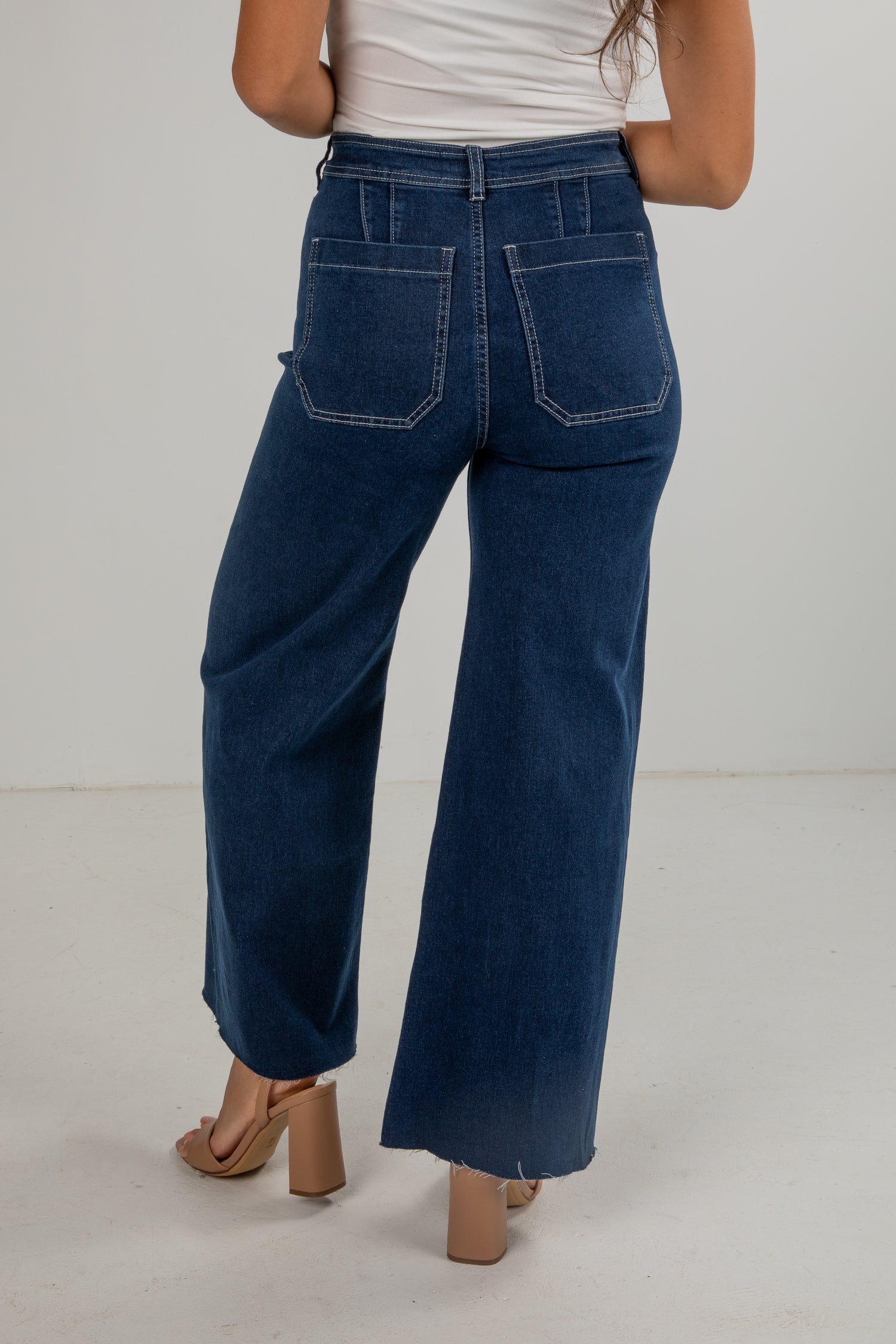 Person wearing blue wide-leg jeans on a plain background