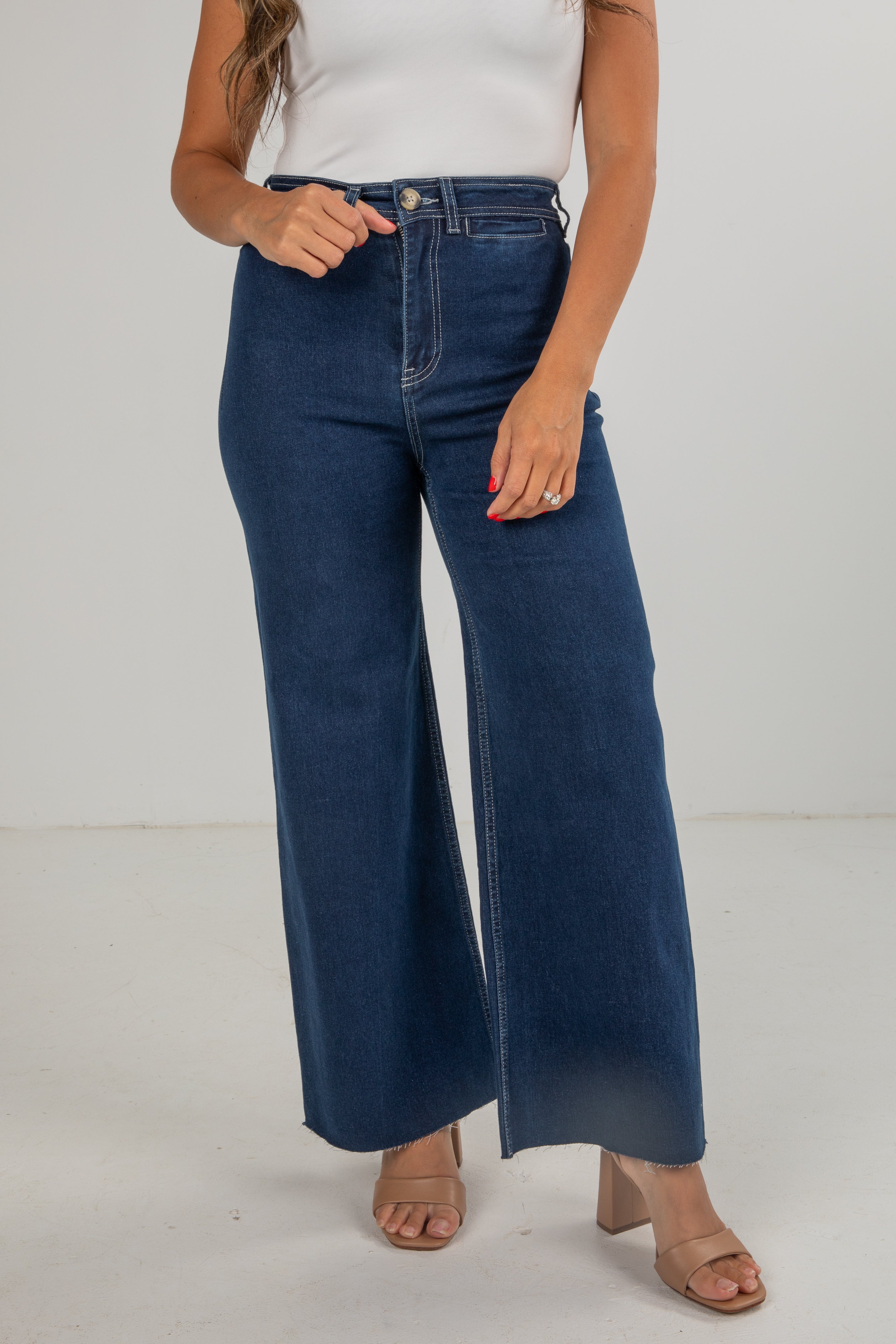 Person wearing blue wide-leg jeans on a plain background