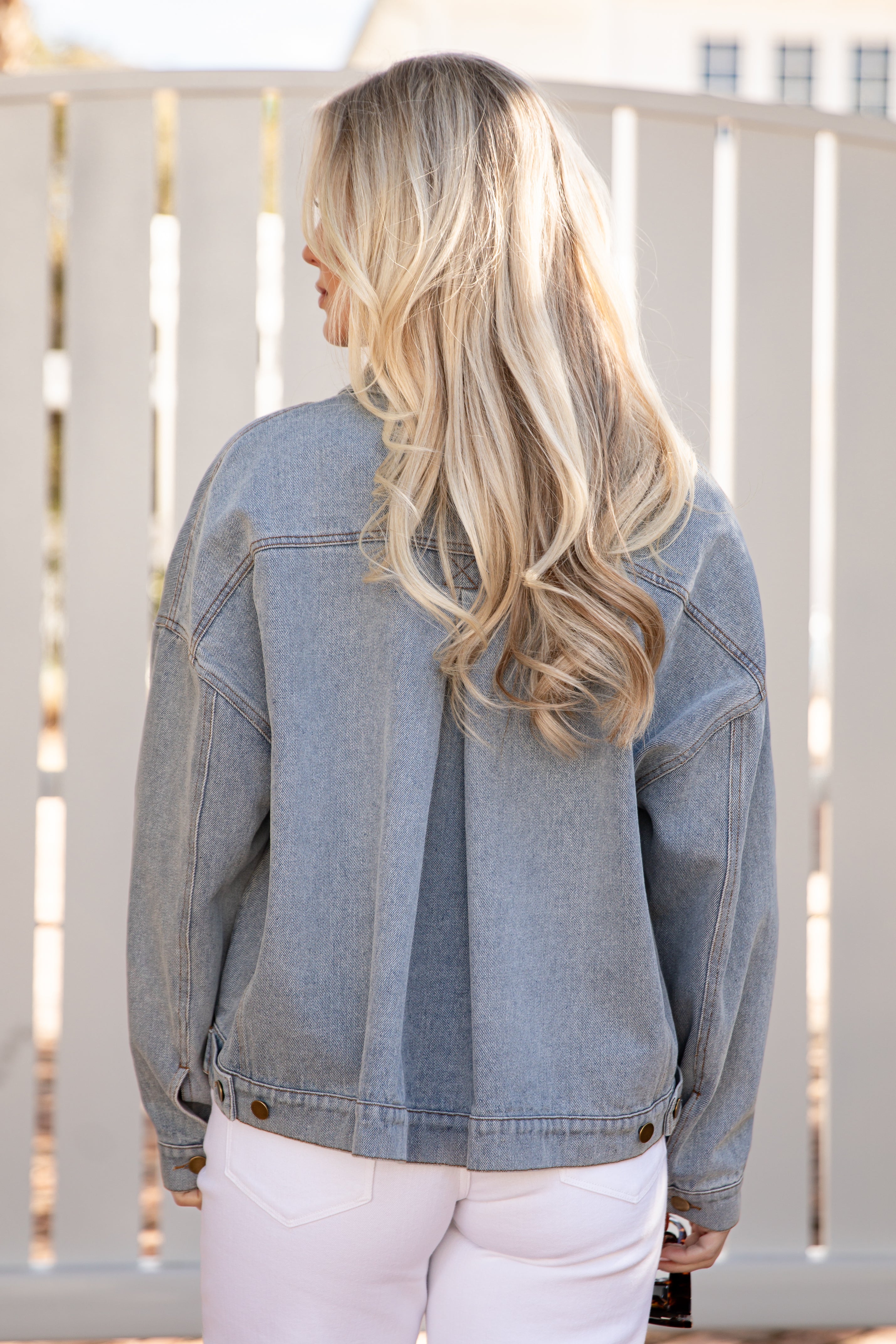 Person wearing a denim jacket with a blurred background