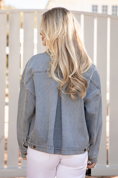 Person wearing a denim jacket with a blurred background
