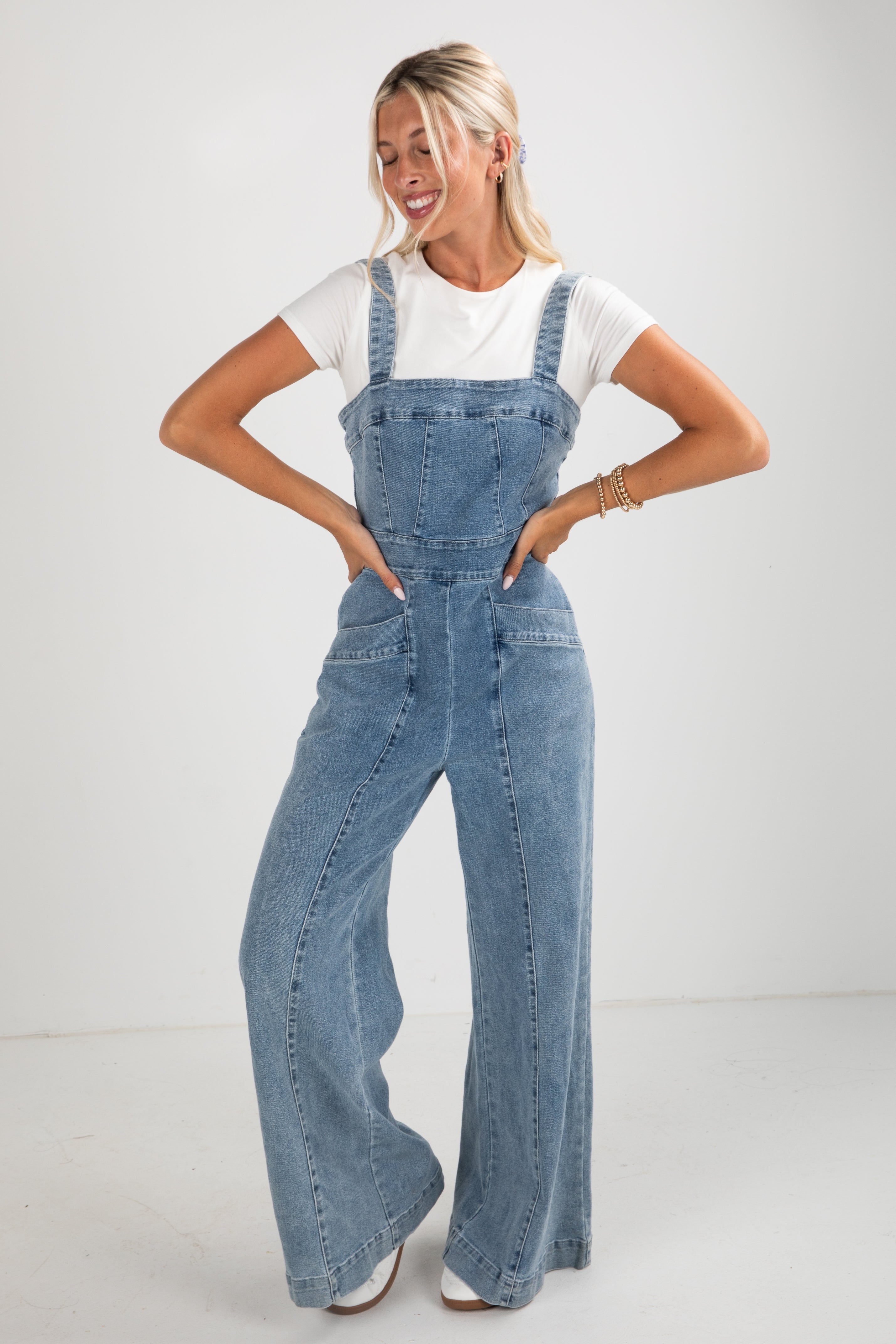 Woman wearing denim overalls on a white background